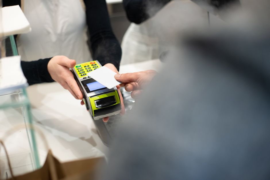 A customer pays with a card at a payment terminal in a modern retail store.