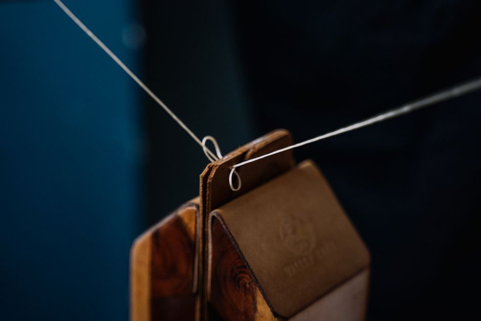 Detailed close-up of leather weights suspended on a wire, showcasing craftsmanship and material texture.