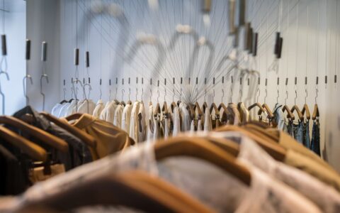A diverse collection of clothes neatly arranged on hangers in a trendy boutique setting.