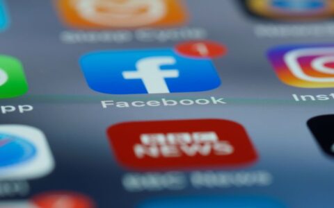 Close-up of smartphone screen displaying various social media app icons including Facebook.