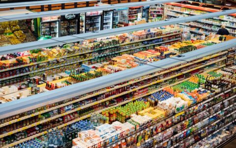 Explore the colorful, fully-stocked shelves of a bustling supermarket from above.